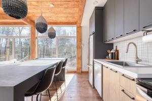 a kitchen with a large island with leather chairs at Slow Living Lodge- SPA - Pet friendly in Saint Come