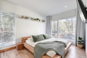 a bedroom with a bed in a room with windows at Slow Living Lodge- SPA - Pet friendly in Saint Come +23 photos