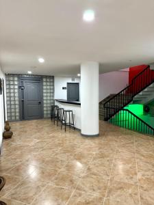 a room with a kitchen with a table and a staircase at Hotel Plaza Mayor 44 in Medellín