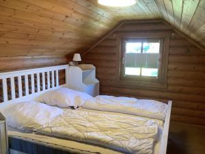 een bed in een houten kamer met een raam bij Blockhaus in Burhave in Hoddersdeich