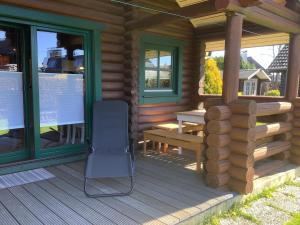 een veranda van een blokhut met een bank en ramen bij Blockhaus in Burhave in Hoddersdeich