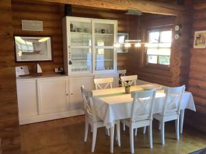 een eetkamer met een witte tafel en stoelen bij Blockhaus in Burhave in Hoddersdeich