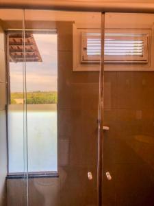 una ducha en un baño con ventana en Paraíso da Barra House, en Cascavel