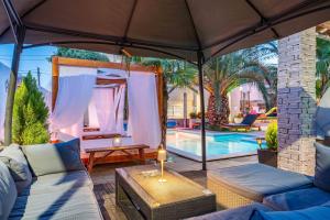 a living room with a couch and an umbrella at Apartments and rooms with a swimming pool Sukosan, Zadar - 5906 in Sukošan