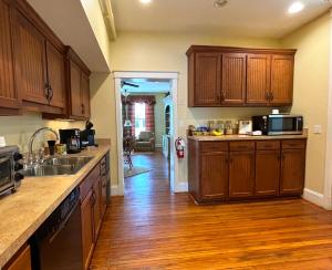 a kitchen with wooden cabinets and a wooden floor at The Grand Lux Inn in Tullahoma