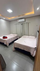 two beds are in a room withermottermottermott at Casa Pé no Sal in Salinópolis +13 photos