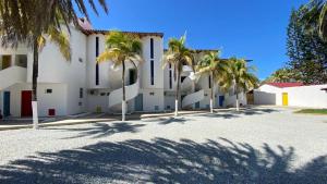 eine Gruppe von Palmen vor einem Gebäude in der Unterkunft Vida Playa el Agua in La Mira