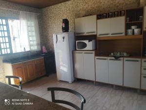 Cianorteにあるcasa aconchegante para seu descansoの冷蔵庫、キャビネット、テーブルを備えたキッチン +6枚の写真