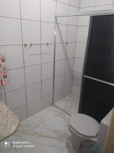 Cianorteにあるcasa aconchegante para seu descansoのトイレとガラスのシャワー付きのバスルーム