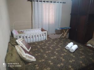 Cianorteにあるcasa aconchegante para seu descansoのベッドルーム1室(ベビーベッド1台、ベビーベッド1台付)