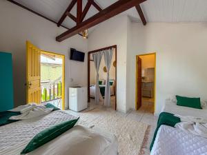 a bedroom with two beds and a door to a balcony at Pousada João Maria in Trancoso
