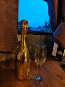a bottle of wine and a glass on a table at Atardecer in Tzicuilán