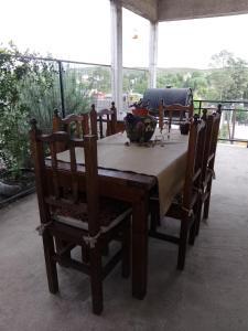 ein Holztisch mit Stühlen und einer Tischdecke darauf in der Unterkunft ENCANTO SERRANO in Villa Carlos Paz