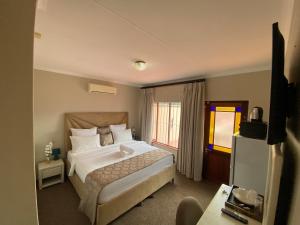 a hotel room with a bed and a window at Kloofyard Guesthouse in Pretoria