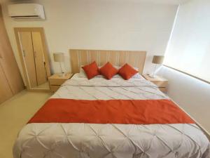 een slaapkamer met een groot bed met rode kussens bij 16 Loft Espectacular - Aire Acondicionado, Consulado in Guadalajara