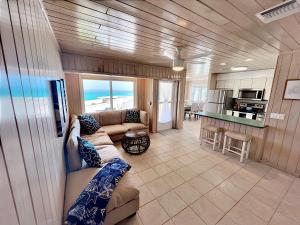 a living room with a couch and a kitchen at Schooners Landing in Abaco