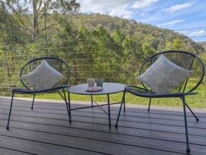 2 sedie e un tavolo su una terrazza di The Burrows Off Grid Cabin, Unplug, Relax & Unwind a Wollombi Altre 13 foto