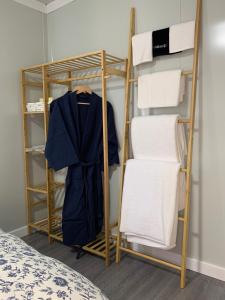 una stanza con un appendiabiti con un accappatoio e degli asciugamani di The Burrows Off Grid Cabin, Unplug, Relax & Unwind a Wollombi