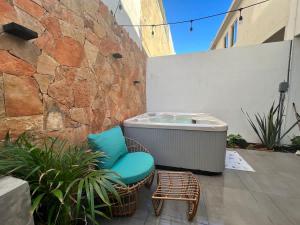 une terrasse avec une chaise et un bain à remous dans l'établissement Modern House with Jacuzzi & Grill 3BR, à La Playita