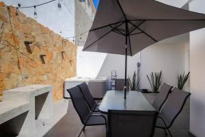- une table et des chaises avec un parasol dans la chambre dans l'établissement Modern House with Jacuzzi & Grill 3BR, à La Playita 45 autres photos