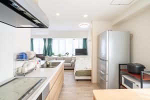 a kitchen with a refrigerator and a living room at 目白 Yoko hotel shinnjuku, shinokubo 10 people stay, big room in Tokyo
