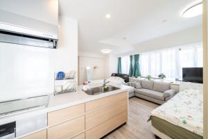 a kitchen and living room with a sink and a couch at 目白 Yoko hotel shinnjuku, shinokubo 10 people stay, big room in Tokyo