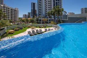 a large swimming pool with chairs in a city at The Wave Resort in Gold Coast +30 photos