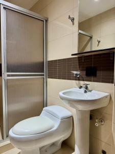 a bathroom with a toilet and a sink at Hotel Plaza Mayor 44 in Medellín +61 photos