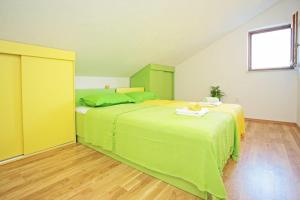 a bedroom with a large bed with green sheets at Apartments with parking space Vrboska, Hvar - 24967 in Vrboska +20 photos