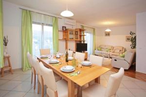 a dining room with a wooden table and chairs at Apartments with parking space Vrboska, Hvar - 24967 in Vrboska