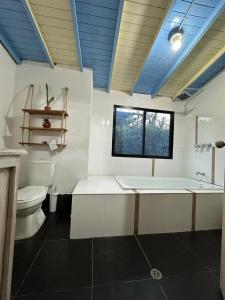 La grande salle de bains est pourvue d'une baignoire et de toilettes. dans l'établissement Refugio del Atardecer, à Guatapé
