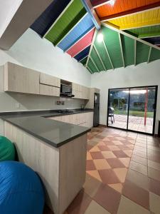 une cuisine avec des plafonds colorés et un grand îlot dans l'établissement Refugio del Atardecer, à Guatapé