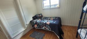 a small room with a bed with a flowered blanket at Casa Club in Puerto Montt