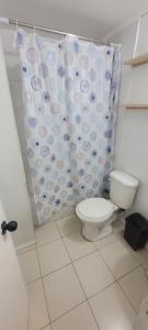 a bathroom with a toilet and a shower curtain at Casa Club in Puerto Montt