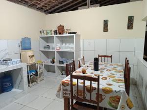 a kitchen with a table and chairs with food on it at Recanto do polly in Lucena