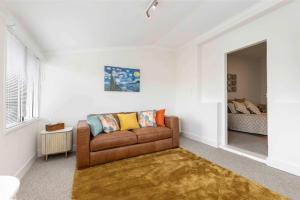 a living room with a couch and a bed at The Golden Key Henley Beach in Henley Beach South +13 photos