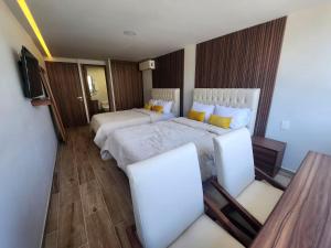 a hotel room with two beds and two chairs at 21 Bella habitación Consulado in Guadalajara