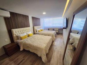 a hotel room with two beds with yellow pillows at 21 Bella habitación Consulado in Guadalajara