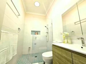 un bagno con doccia, WC e lavandino di Tranquil Suites in Heart of Leura 3 Minutes to Shops a Leura Altre 29 foto