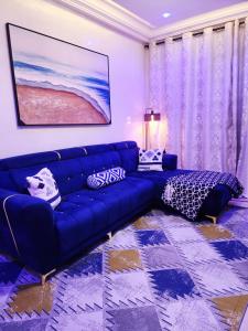 a blue couch in a living room with a painting at STUDIO pour les personnes a mobilité réduite in Dakar