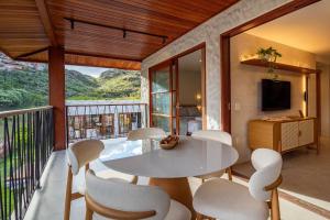 a dining room with a table and chairs on a balcony at Apartamento Luxuoso com Vista para as Montanhas in Mucugê