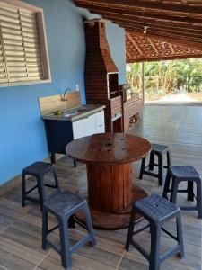 a kitchen with a table and stools and a sink at Chácara pedacinho do paraíso in Cesário Lange