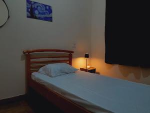 a bedroom with a bed and a lamp on a table at Chácara pedacinho do paraíso in Cesário Lange