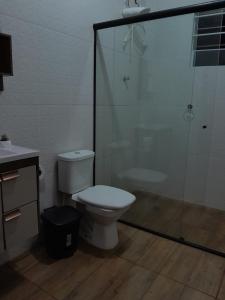 a bathroom with a toilet and a glass shower at Chácara pedacinho do paraíso in Cesário Lange +28 photos
