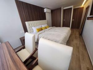 een slaapkamer met een groot wit bed met gele kussens bij 22 Bella habitación Consulado in Guadalajara