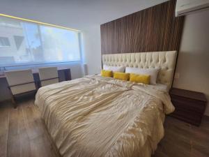 een slaapkamer met een groot bed met gele kussens bij 22 Bella habitación Consulado in Guadalajara