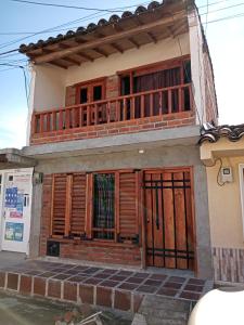 a house with wooden doors and a balcony at La Victoria, Valle te espera in La Victoria