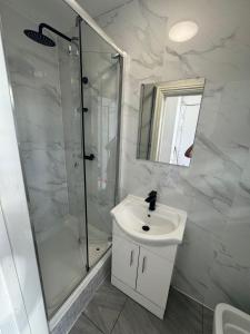 een witte badkamer met douche en wastafel bij Family room in Zone 2 in Londen +12 foto's