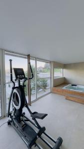 - une salle de sport avec un tapis de course dans une pièce dotée de fenêtres dans l'établissement Réveillon 2026 CASA LOS PADEL - Vitorino dos Piães, à Navio