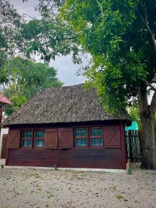 a small red building with a grass roof at Cabañas Bacali in Bacalar